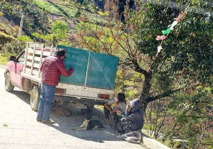 Professor pendura lousa em caminhão e dá aulas em área rural